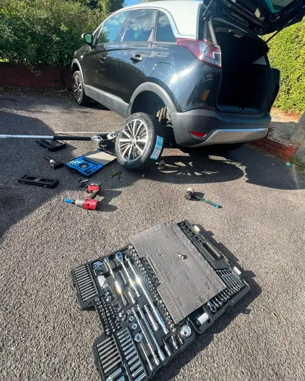 Tyre replacement on the driveway with tools laid out